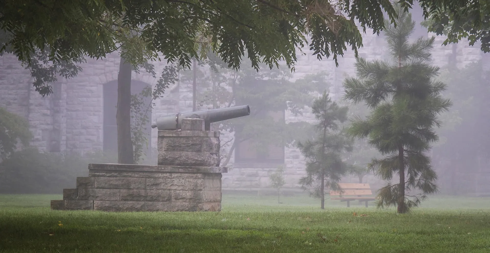 The cannon on its stone base in morning fog